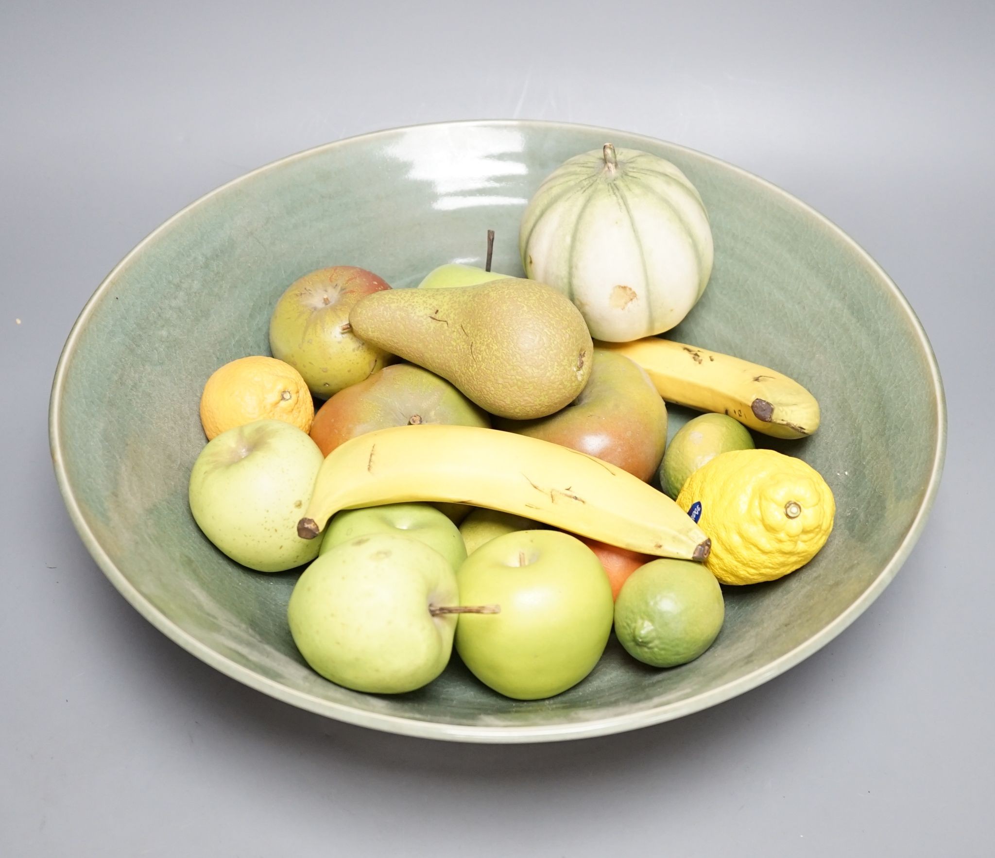 A collection of vintage Penkridge ceramic fruit including a pomegranate, melon, two bananas, limes, lemon, pear etc (18 items) in a green ceramic bowl, 42cm diameter